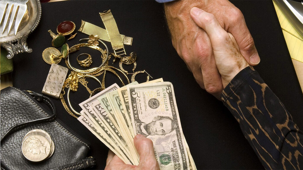 handshake with exchange of dollars and jewelry