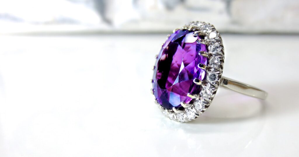 purple diamond ring surrounded by smaller diamonds