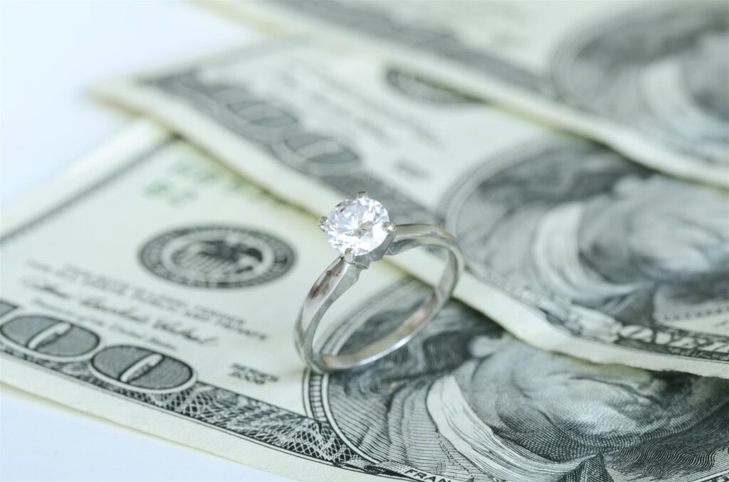 diamond ring with hundred dollar bills behind