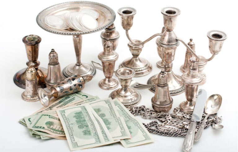 silver candle holders and hundred dollar bills