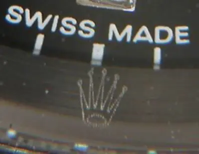 Close-up of Rolex crown logo on dial and tiny etched crystal crown on authentic watch compared to misaligned and flawed fake.
