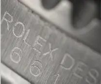 Genuine Rolex serial number with sharp diamond-cut engraving compared to a fake with rough, shallow etching.